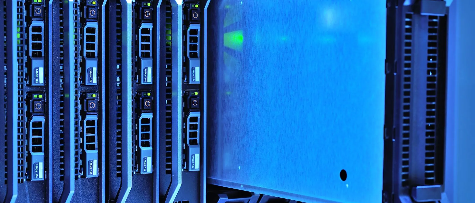 Rows of server racks with small glowing indicator lights in a dark data centre.