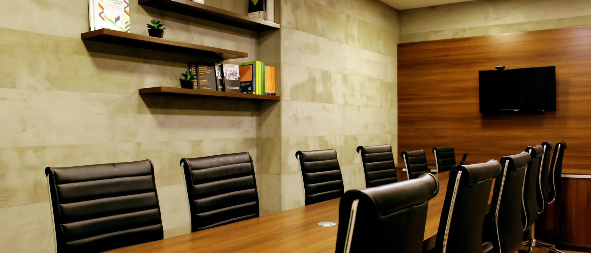 Black leather chairs around a boardroom table in a wood-panelled room.