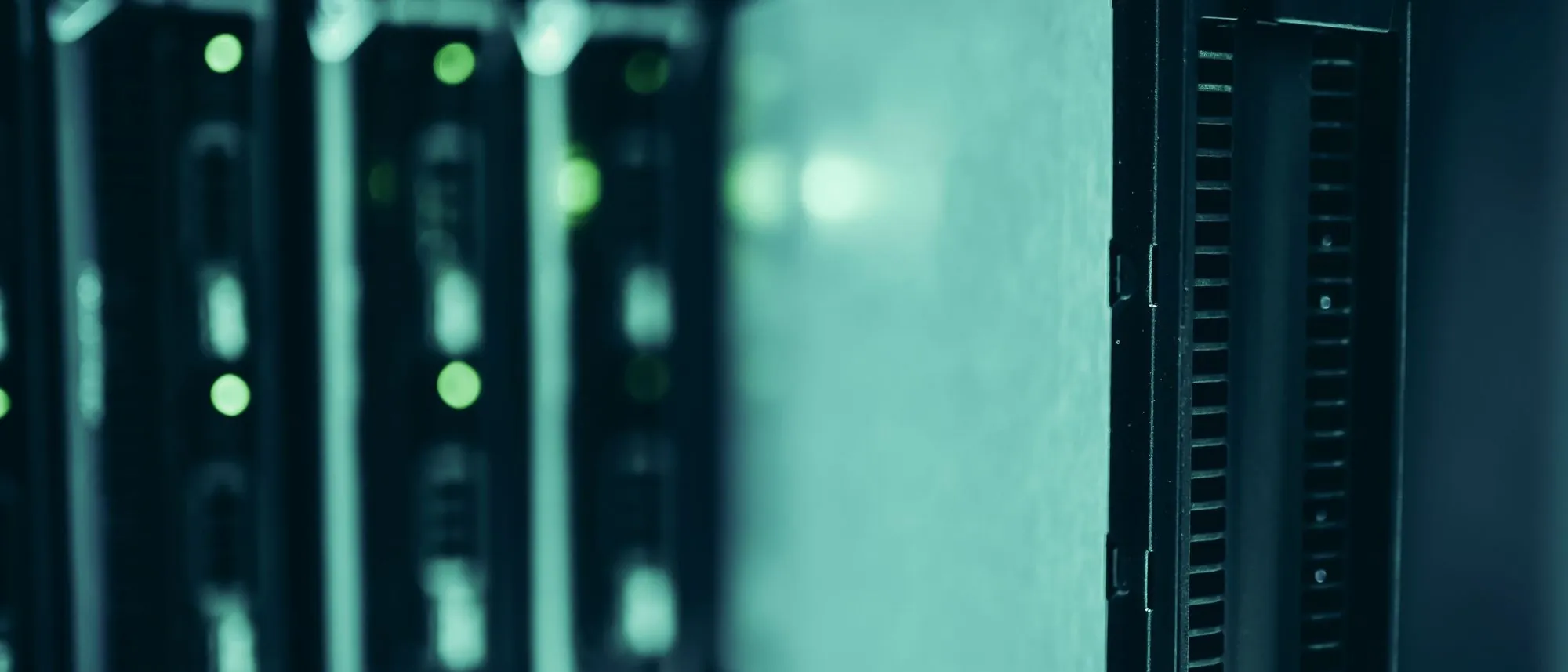 Server racks with blinking equipment line an aisle in a data centre.