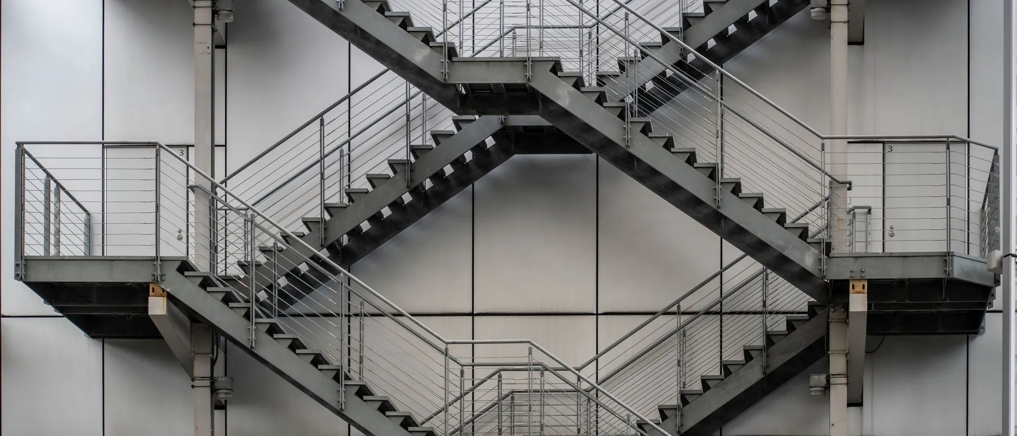 Metal staircases crossing one another on the outside of an industrial building in Tokyo.