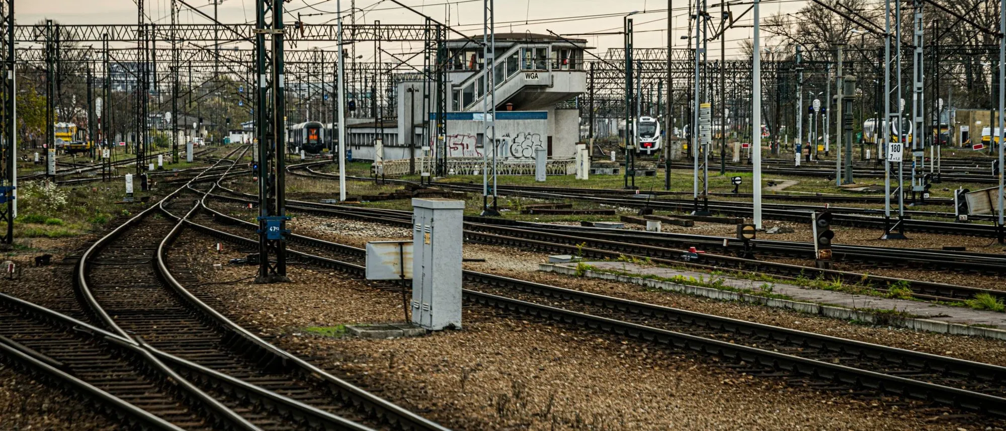 A railway junction where many tracks cross and divide under a cloudy sky.