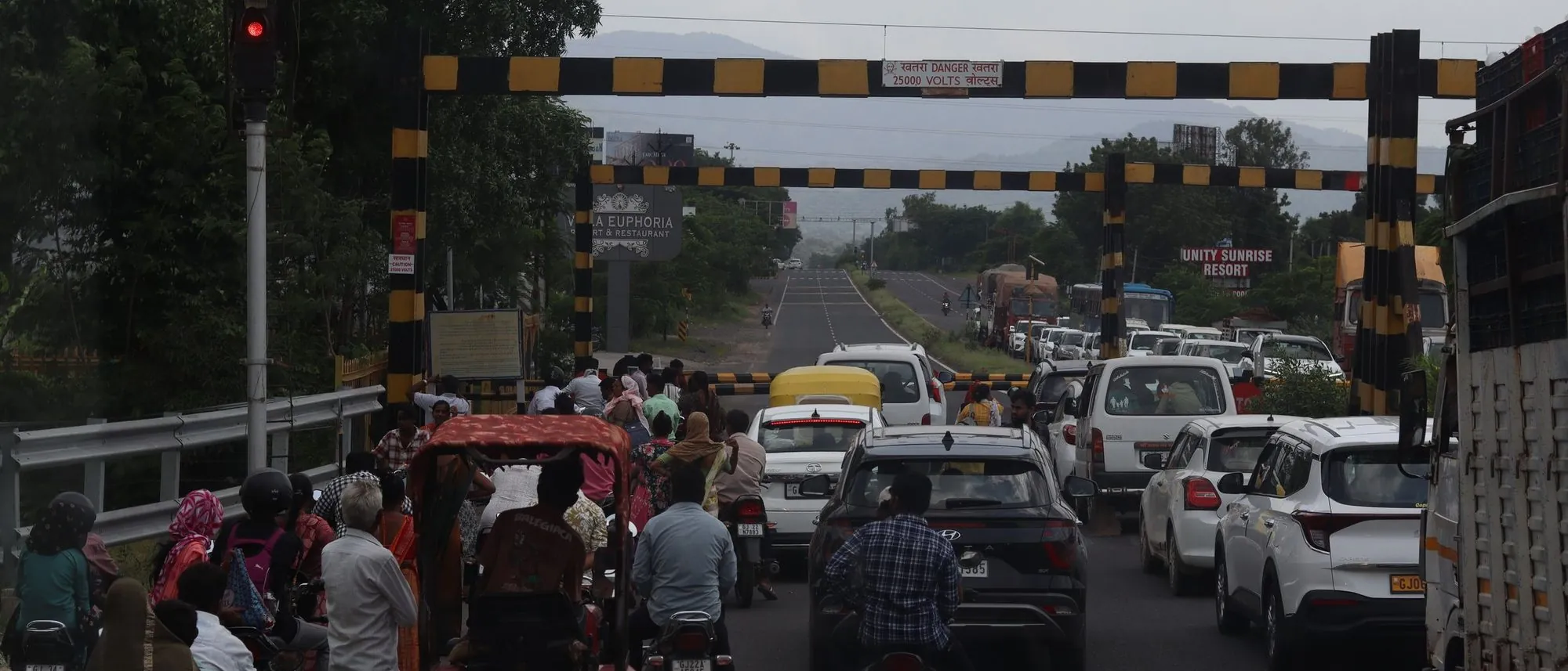 Cars trucks and two-wheelers crowd a highway underpass in India.