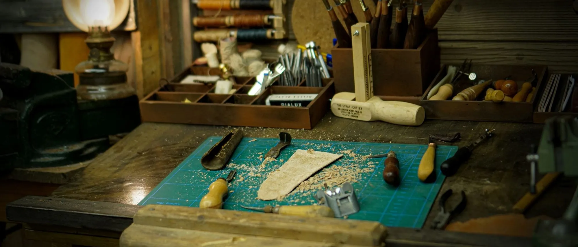 A vintage workshop table laid with hand tools and wooden parts.