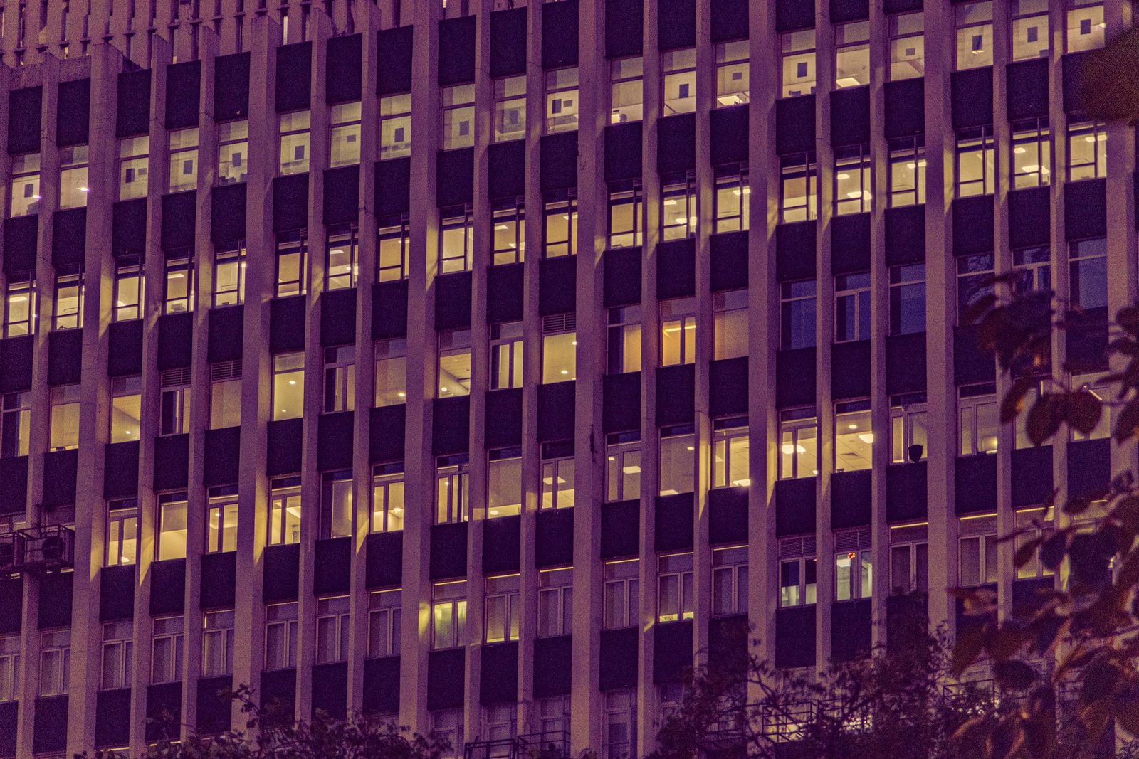 The lit windows of an office building in New Delhi at night.