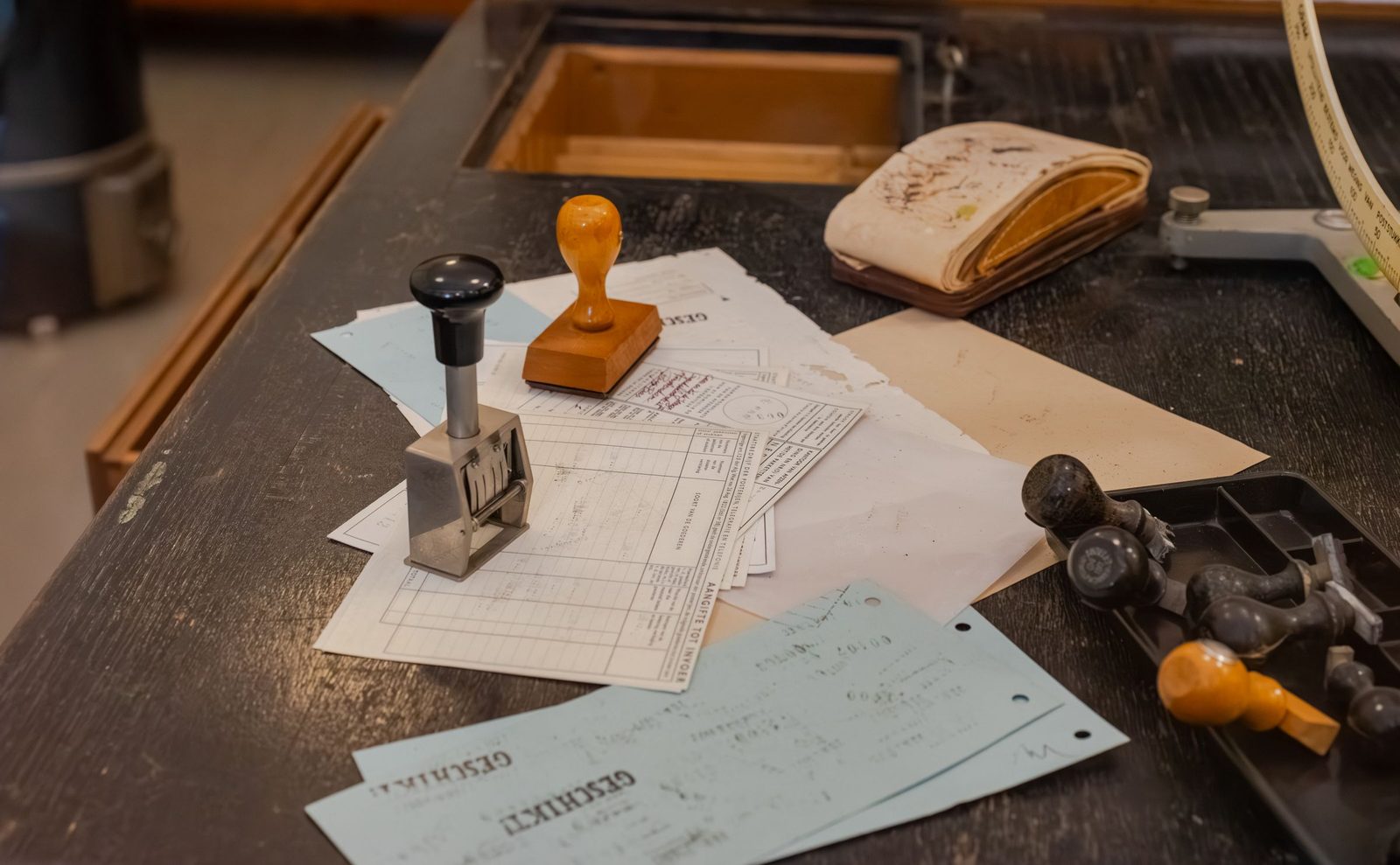 Office rubber stamps lying on a cluttered desk of documents.