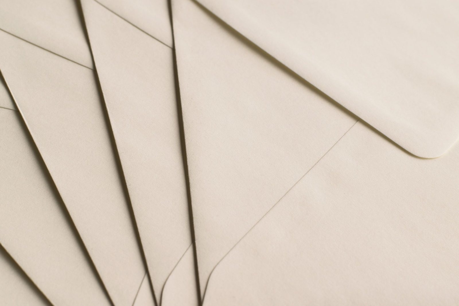 Plain beige envelopes arranged on a neutral background.