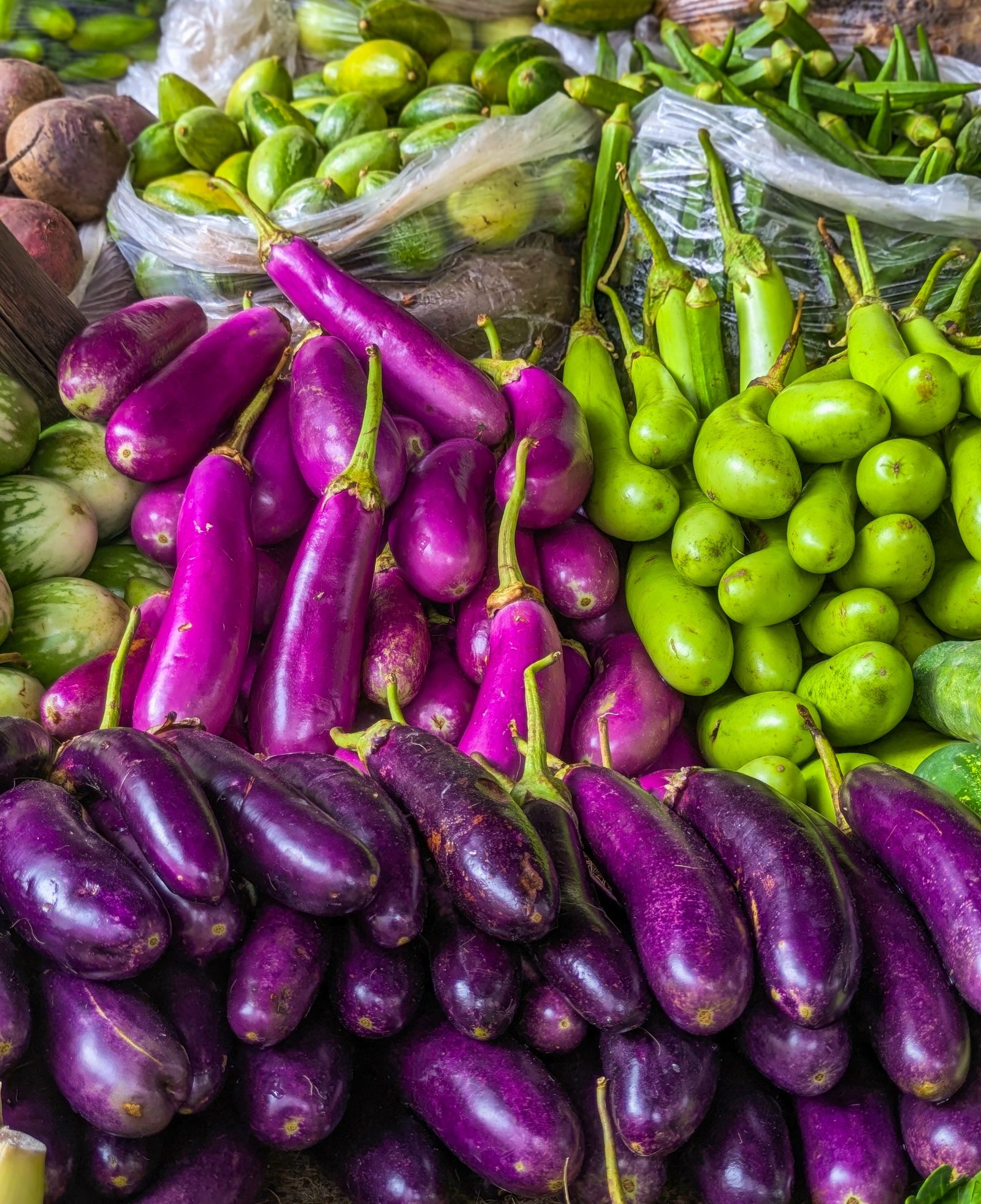 Eggplants and gourds piled on a vegetable stall at a New Delhi market.