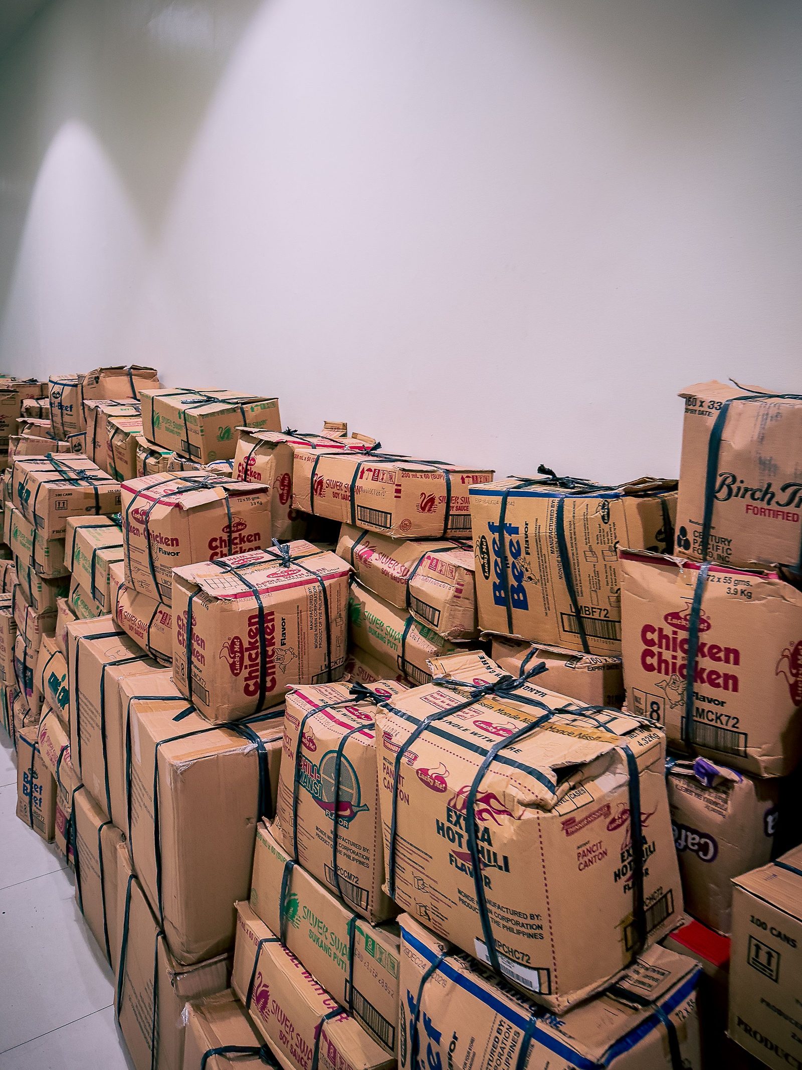 A tall stack of cardboard boxes inside a warehouse.