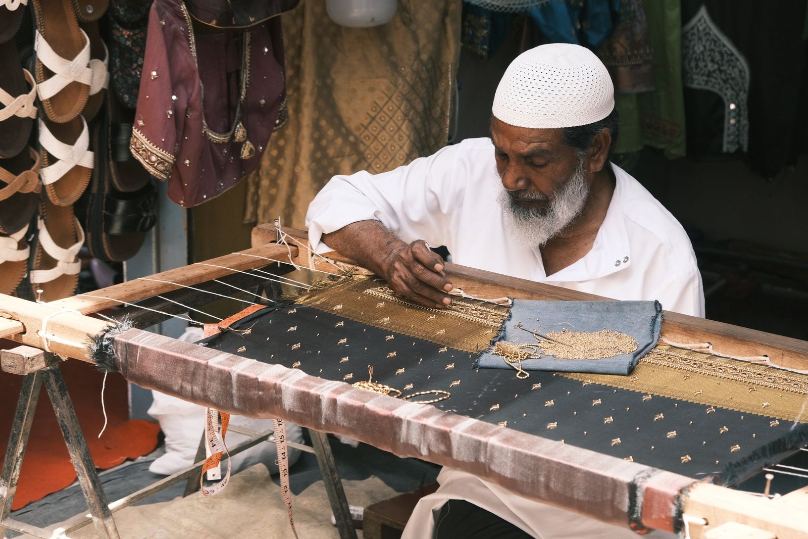 A textile artisan works at a street-side stall in Bengaluru.
