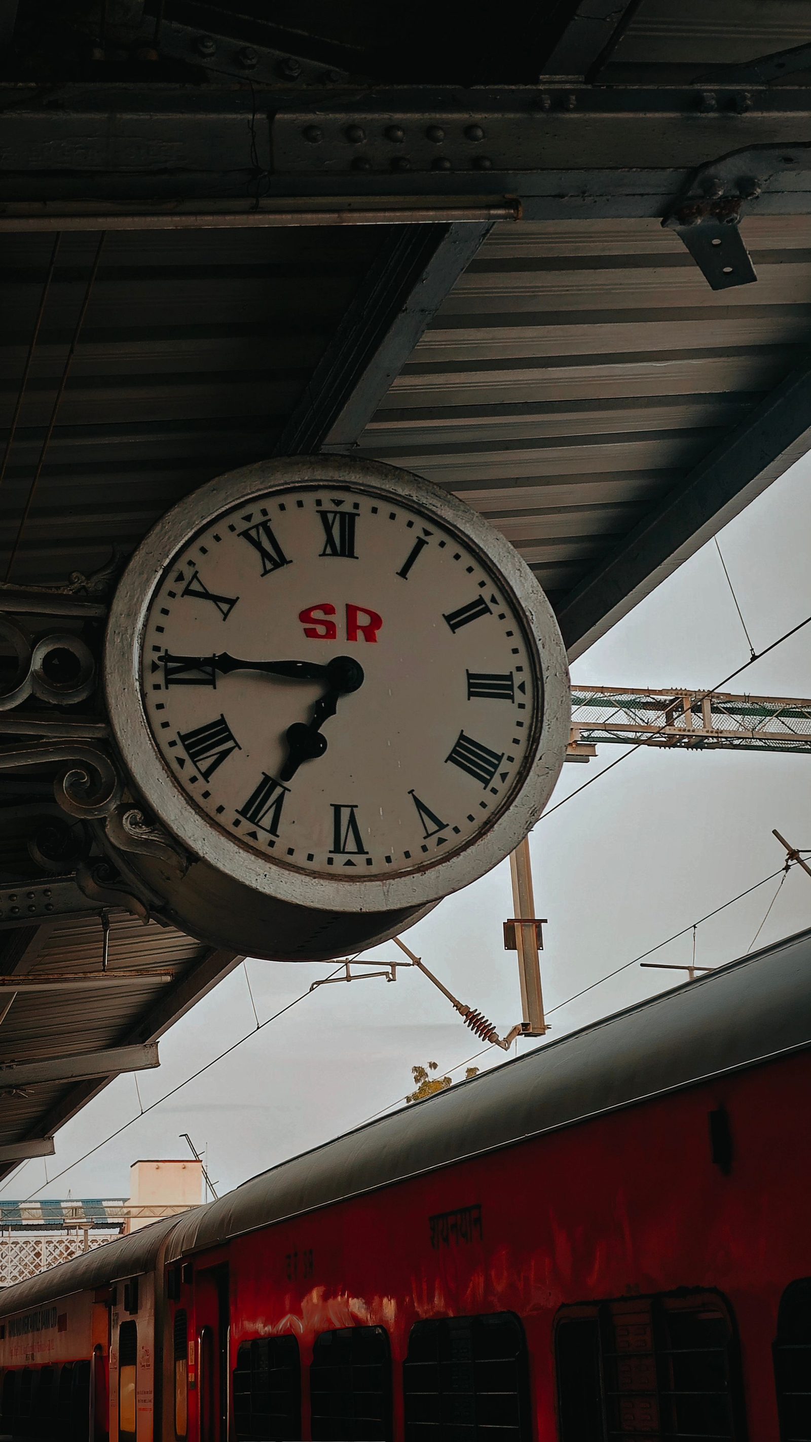 An analogue clock on the platform at Dindigul railway station.
