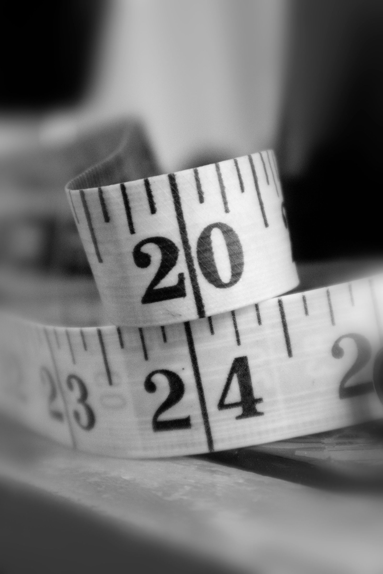 A curled measuring tape photographed in black and white.