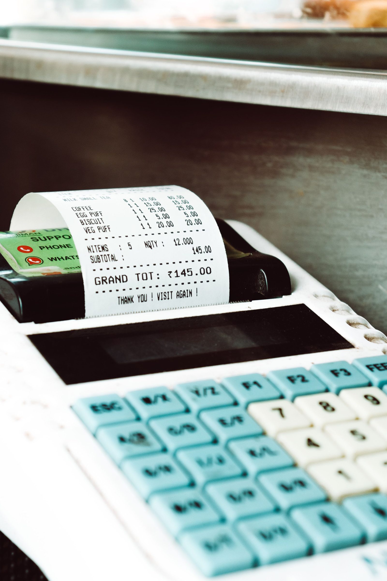 A shop till prints a paper receipt with a payment card lying beside it.