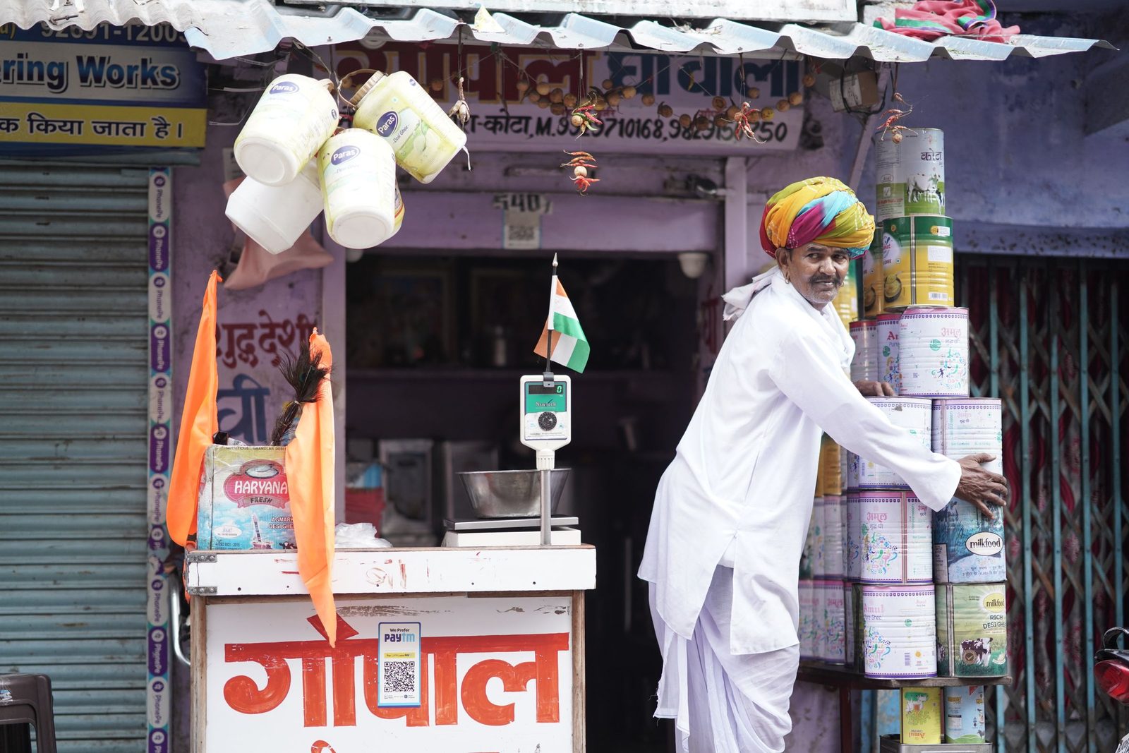 A shopkeeper in a turban arranges stock outside his shop in Kota, Rajasthan.