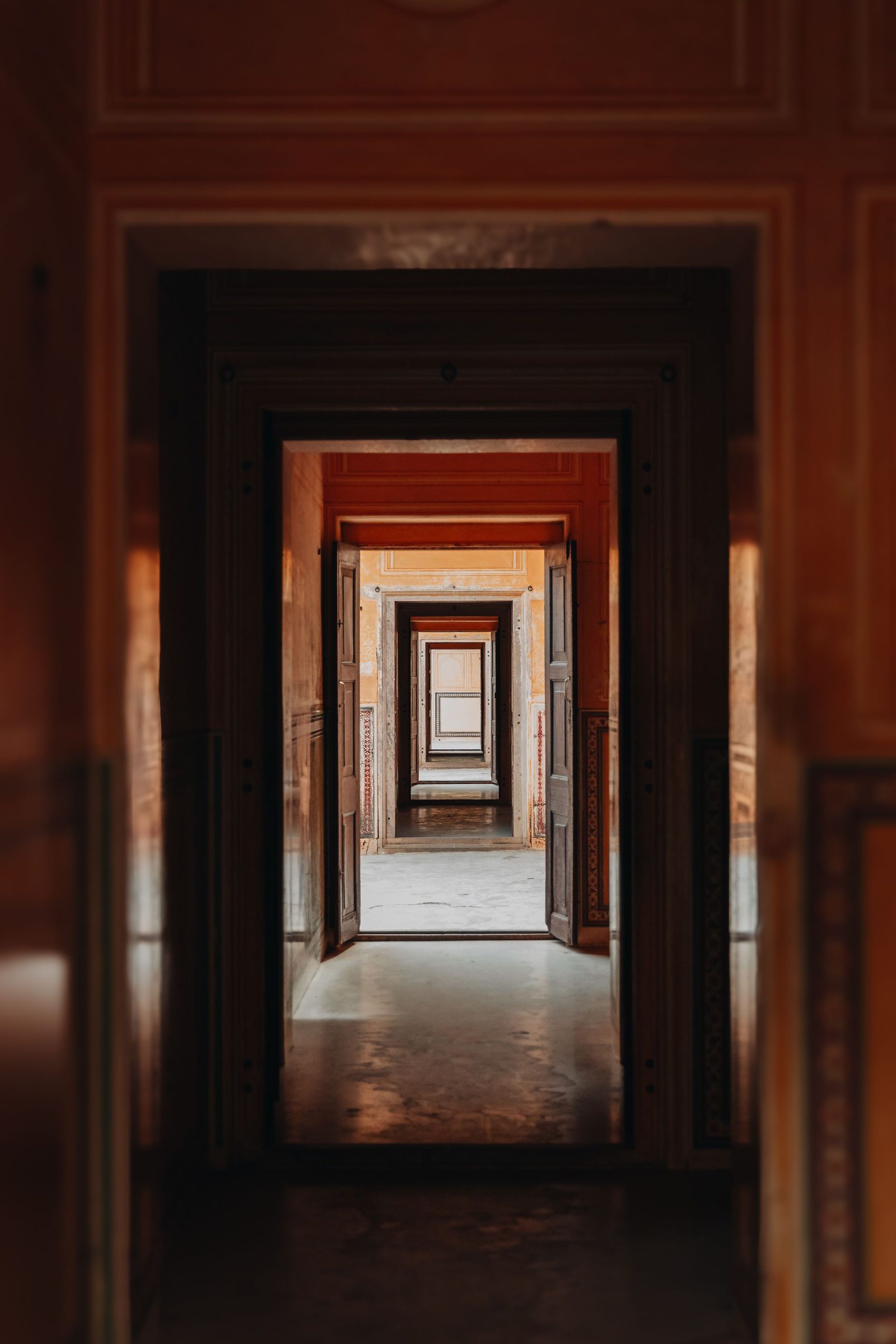 A symmetrical row of arched doorways recedes down a corridor in a Jaipur palace.