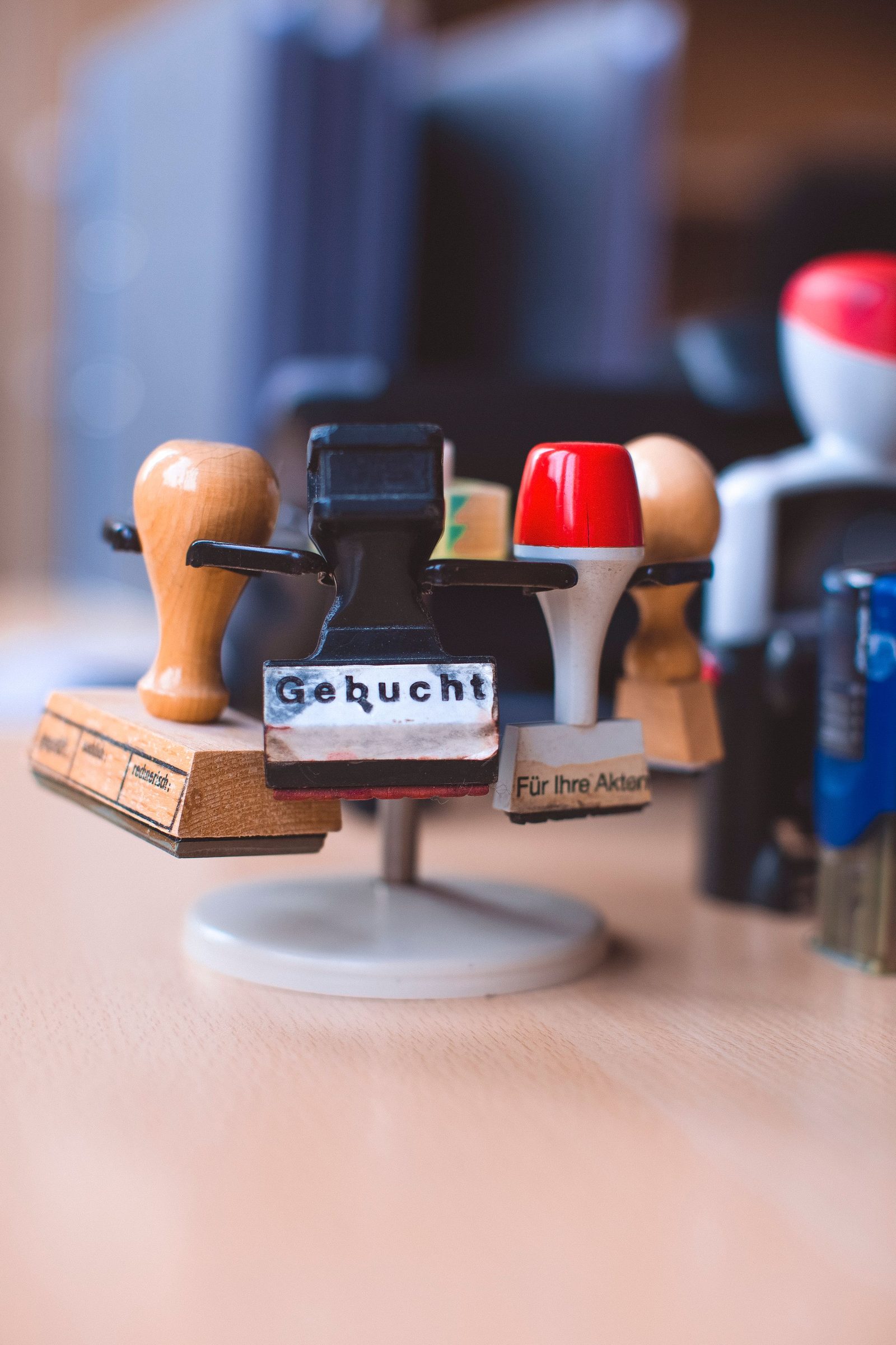 Several rubber stamps hang from a desk stand in an office.