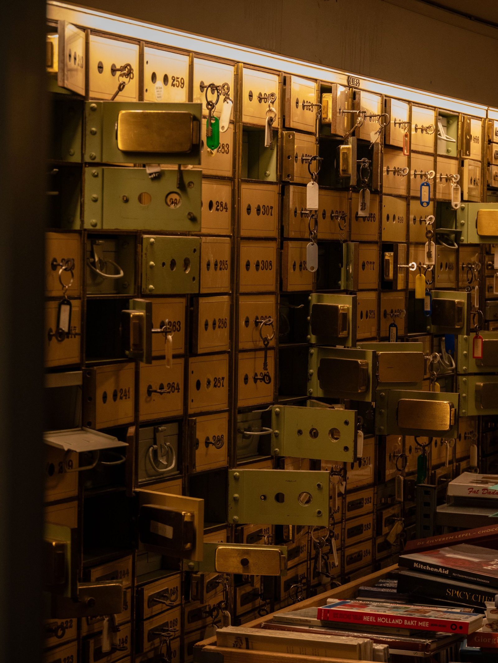 Vintage safe deposit boxes with keys in a dimly lit room.