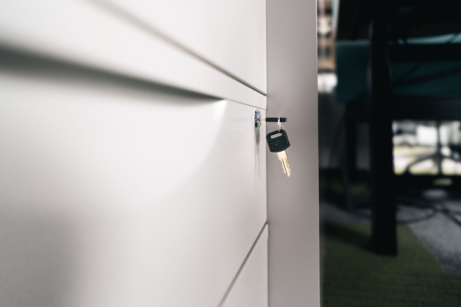 A key sits in the lock of a closed office drawer.