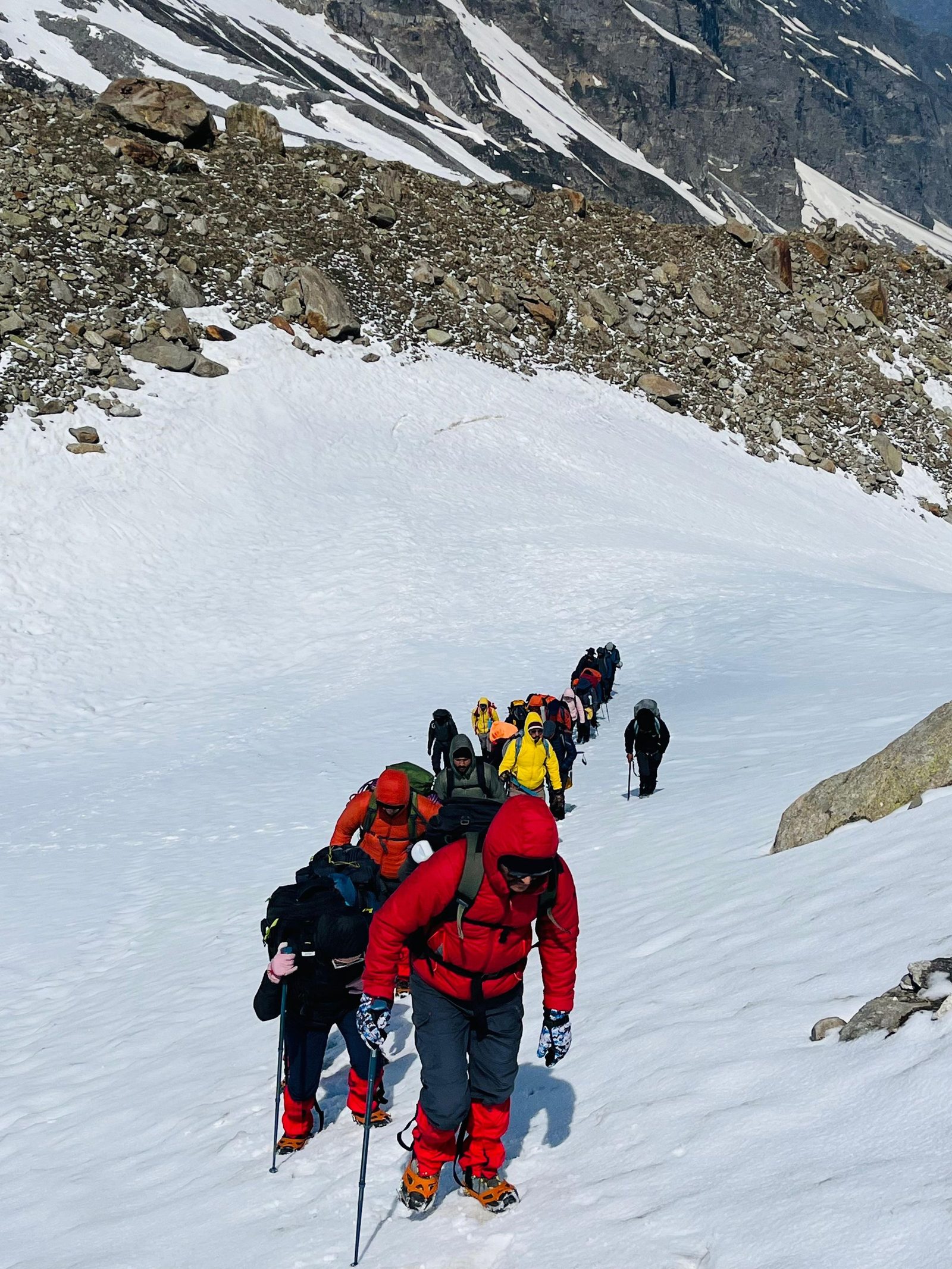 A line of trekkers climbs through deep snow at Hampta Pass in Himachal Pradesh.
