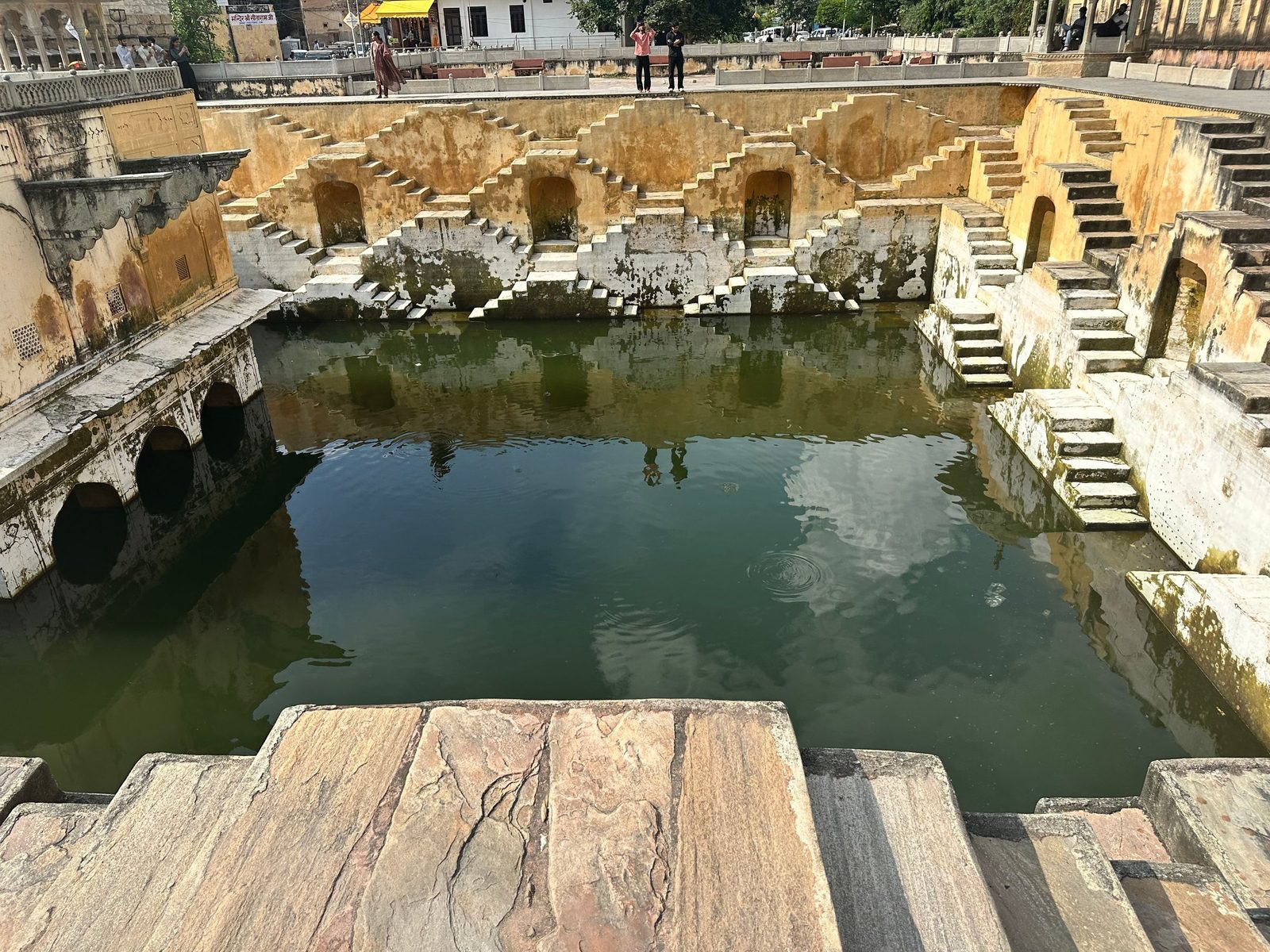 An old stepwell in India with its steps reflected in the water below.