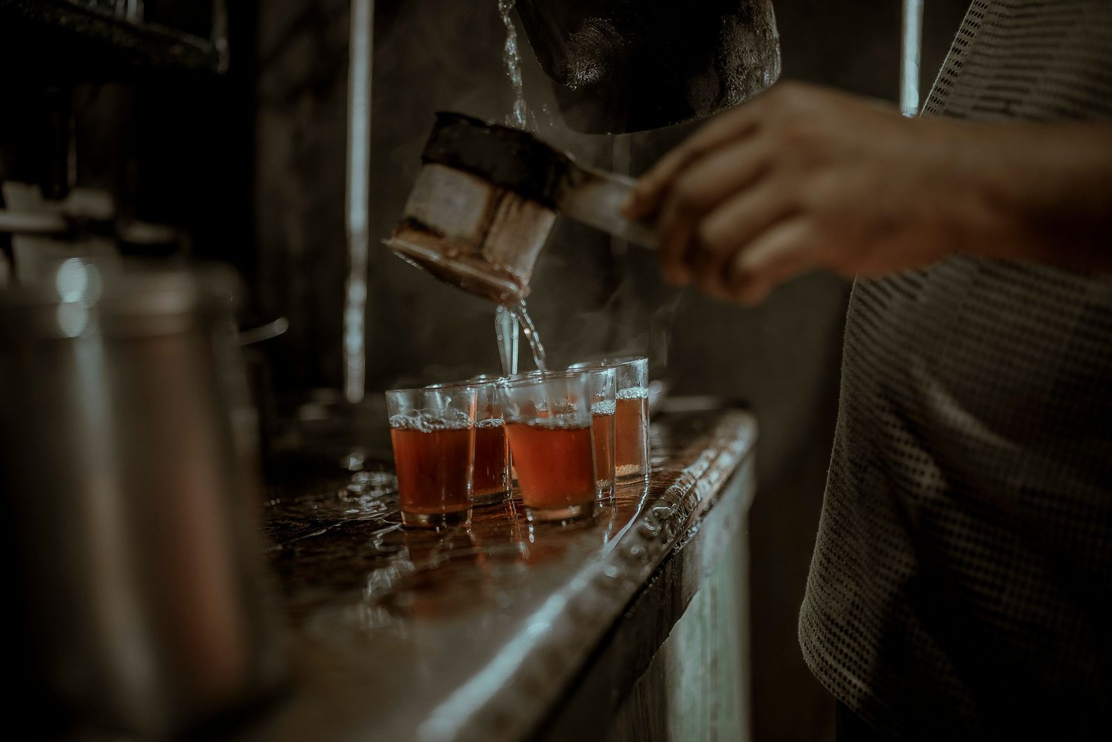 Tea being poured into a row of glasses in Darjeeling.