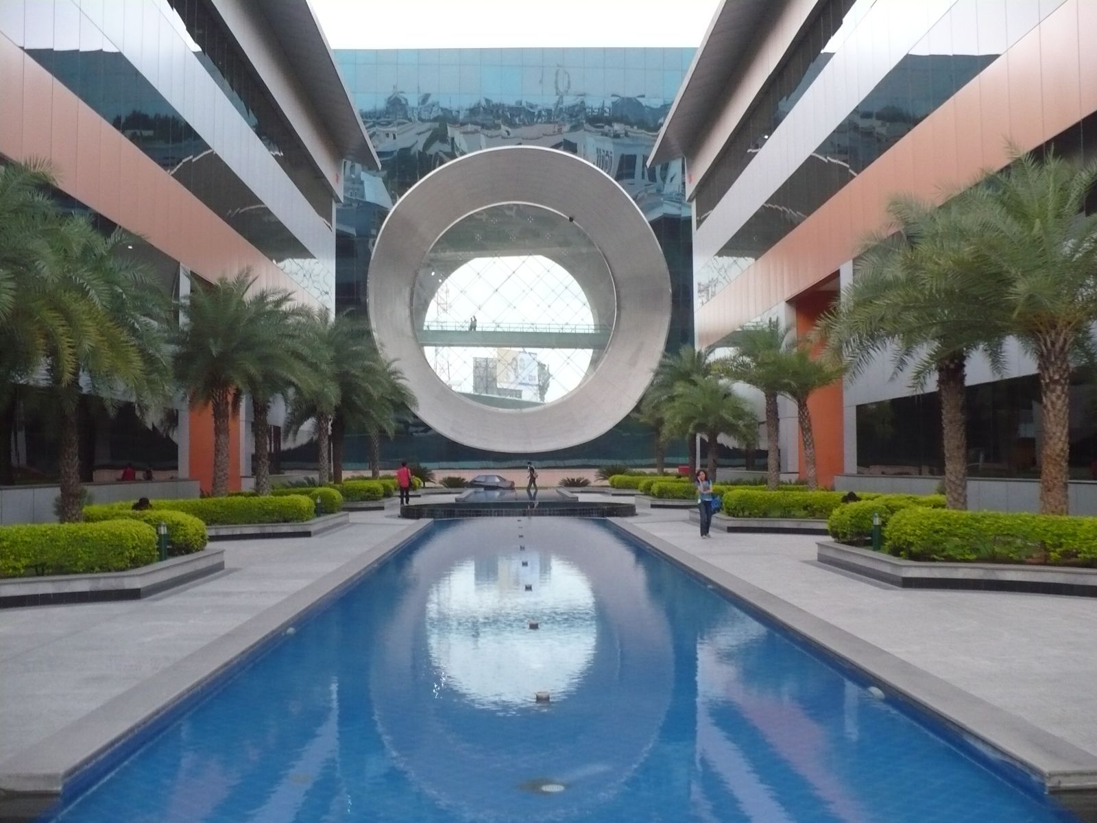 The Infosys campus at Electronic City, Bengaluru, with its round glass building reflected in a pool