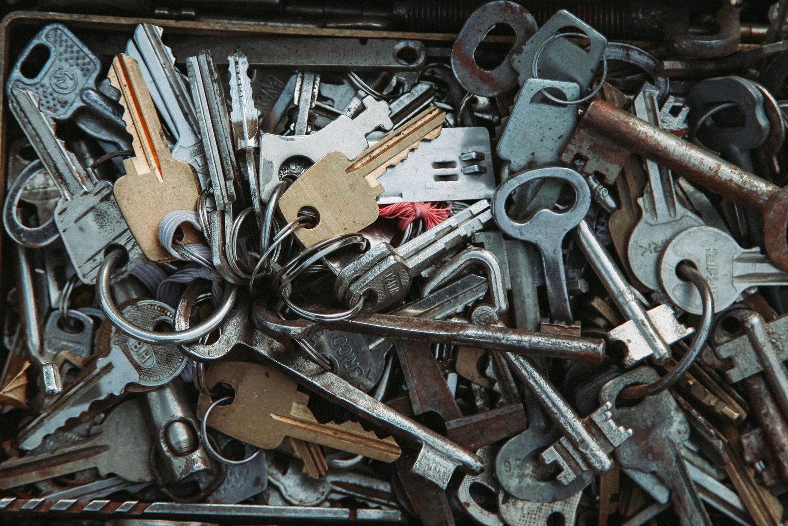 A pile of rusty metal keys of different shapes and sizes lying together.