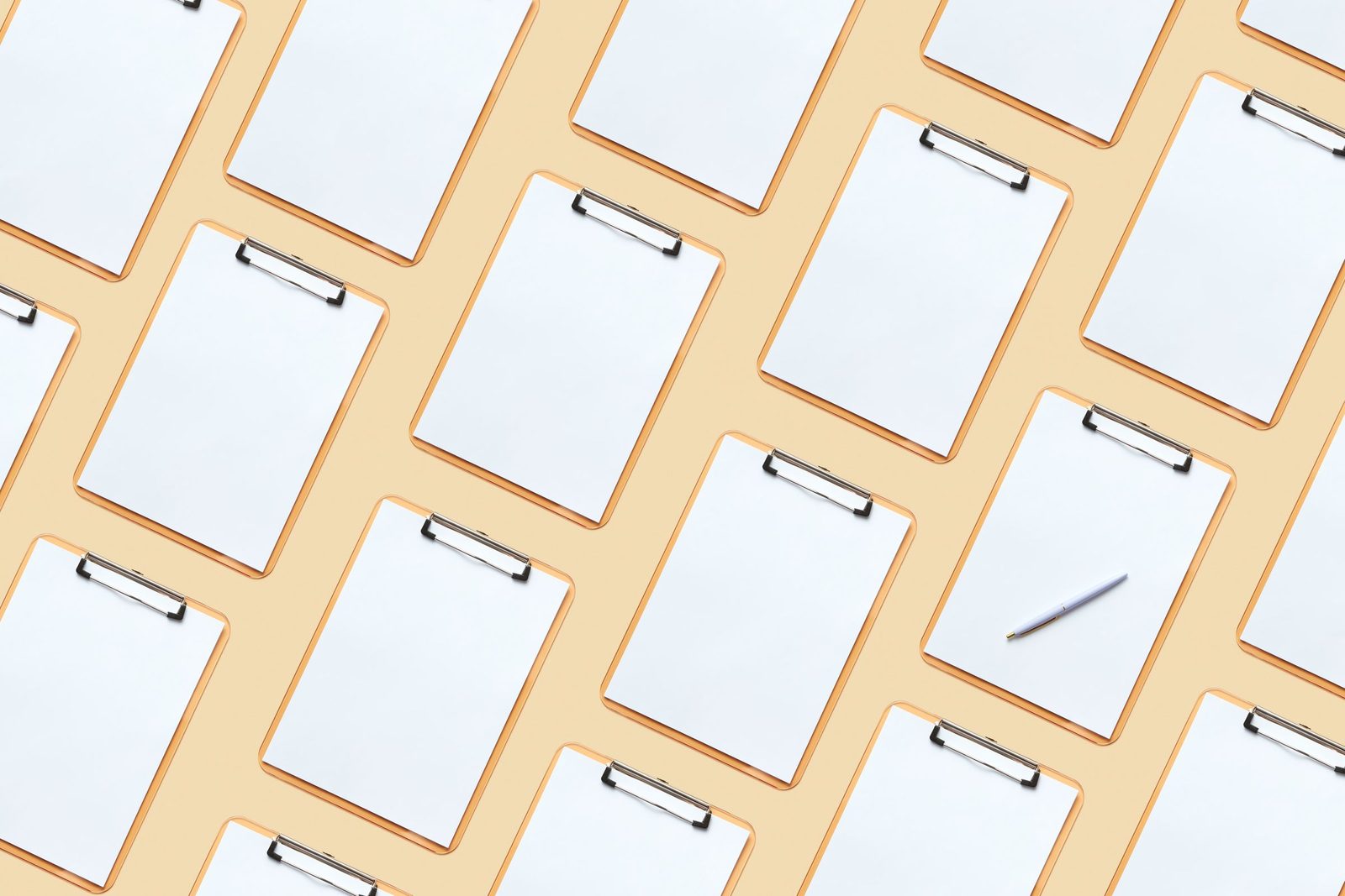 Several blank clipboards laid out on a pastel surface.