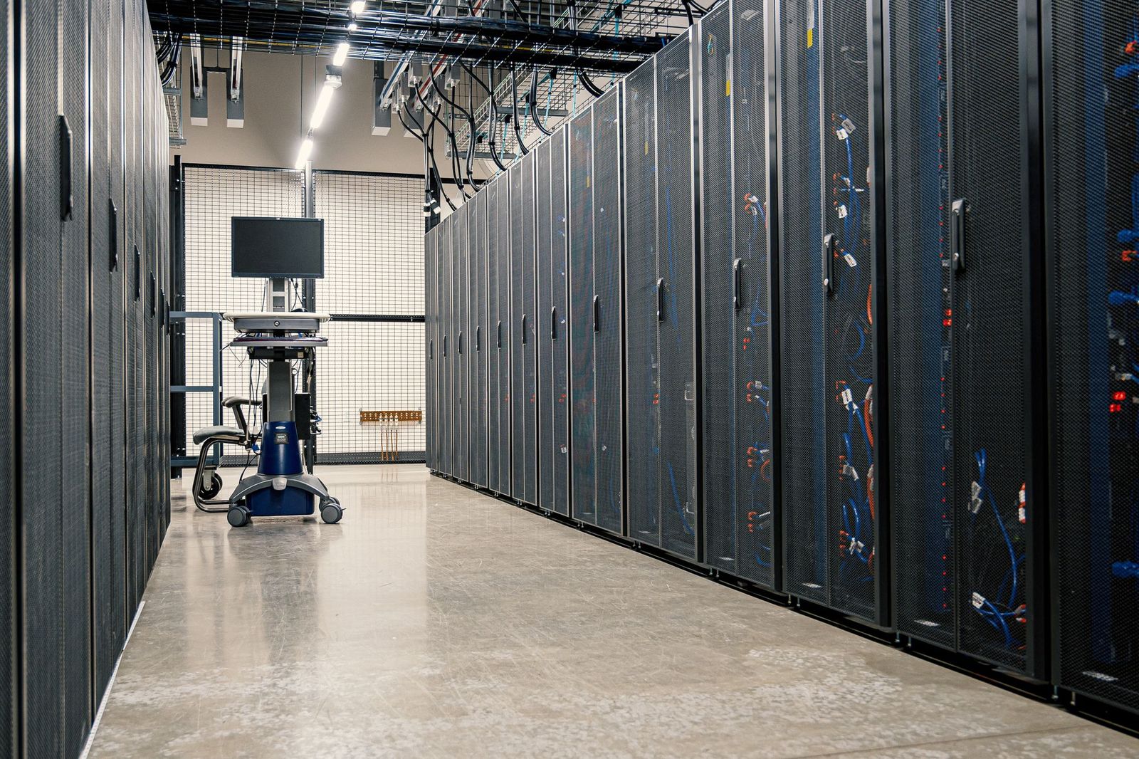 An aisle of black server racks in a data centre