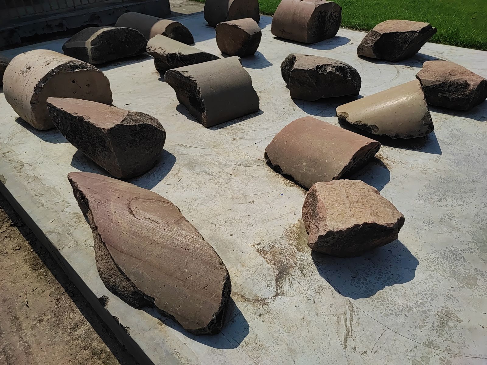 Broken sandstone pillar stumps of the Mauryan pillared hall laid out on a plinth at Kumhrar, Patna