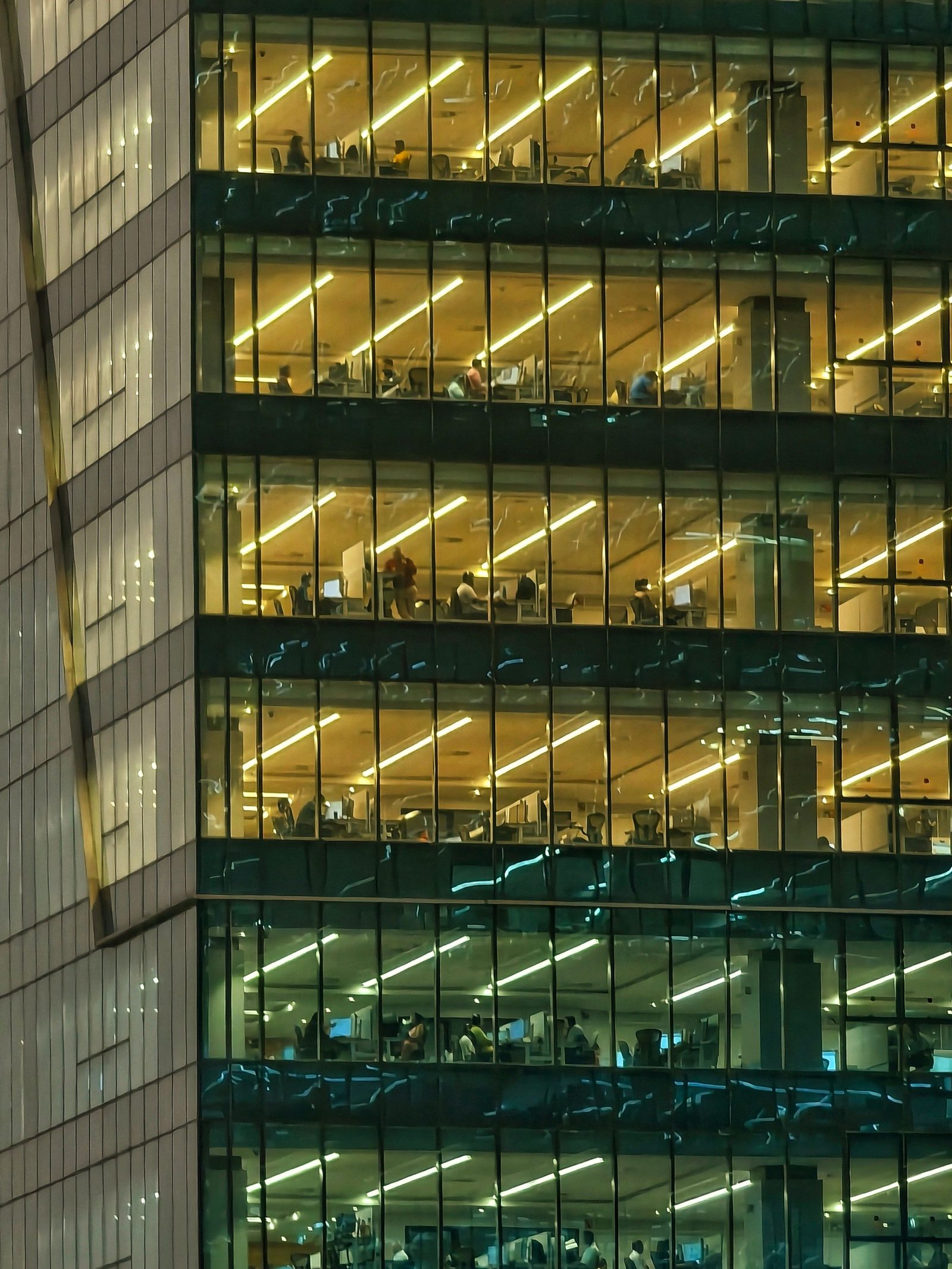 A modern office building in Hyderabad lit from inside at night.