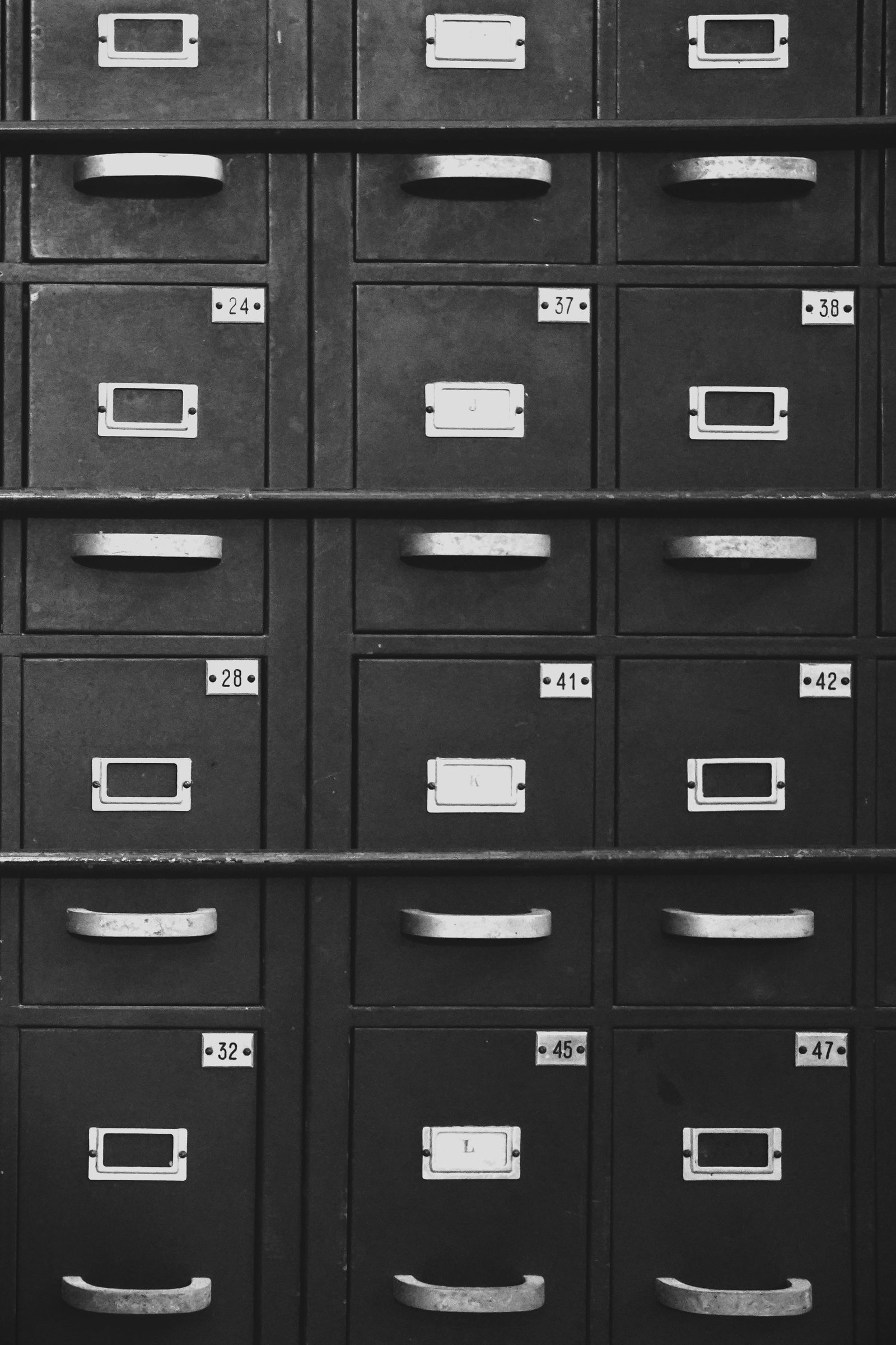 Rows of numbered metal filing drawers in black and white.