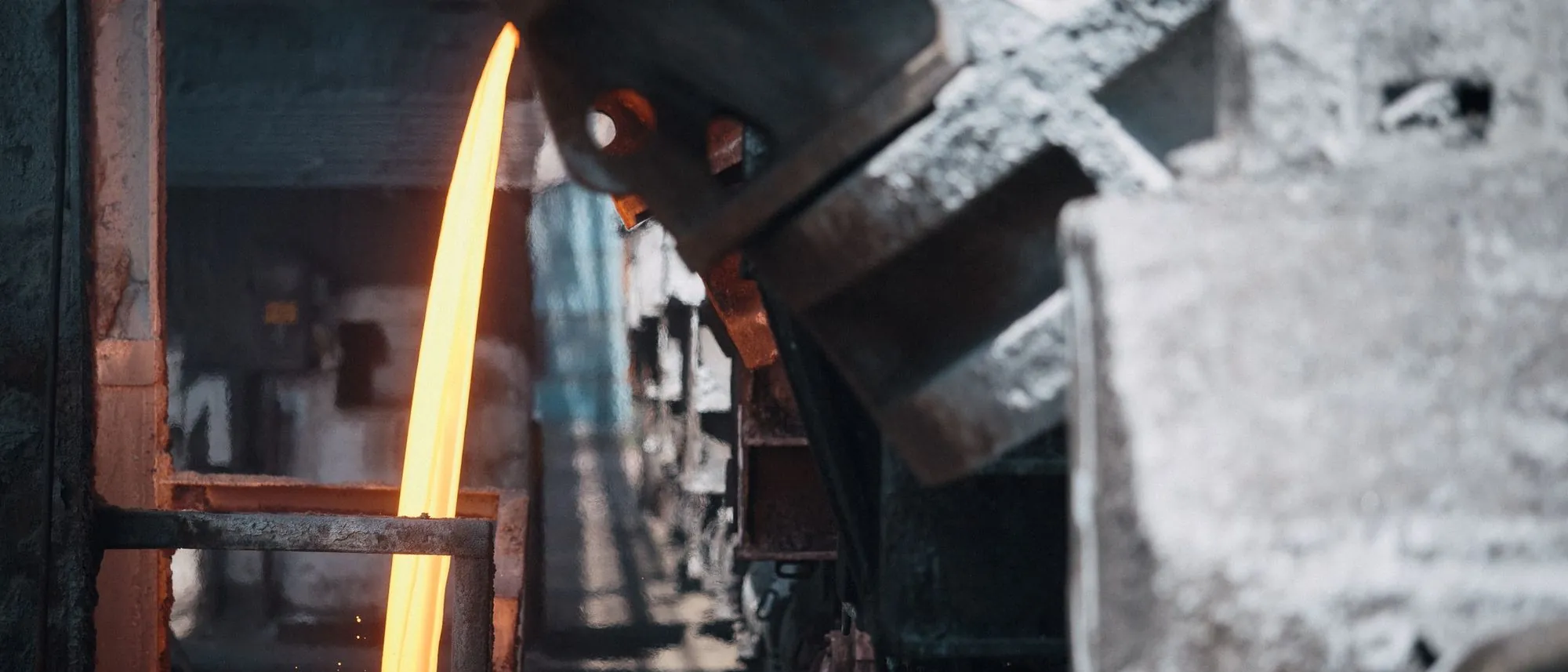 Molten metal pouring from vats on wagons inside a steelworks.