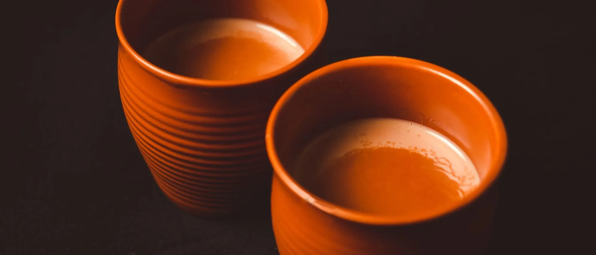Clay cups of chai stand together on a surface in Bengaluru.