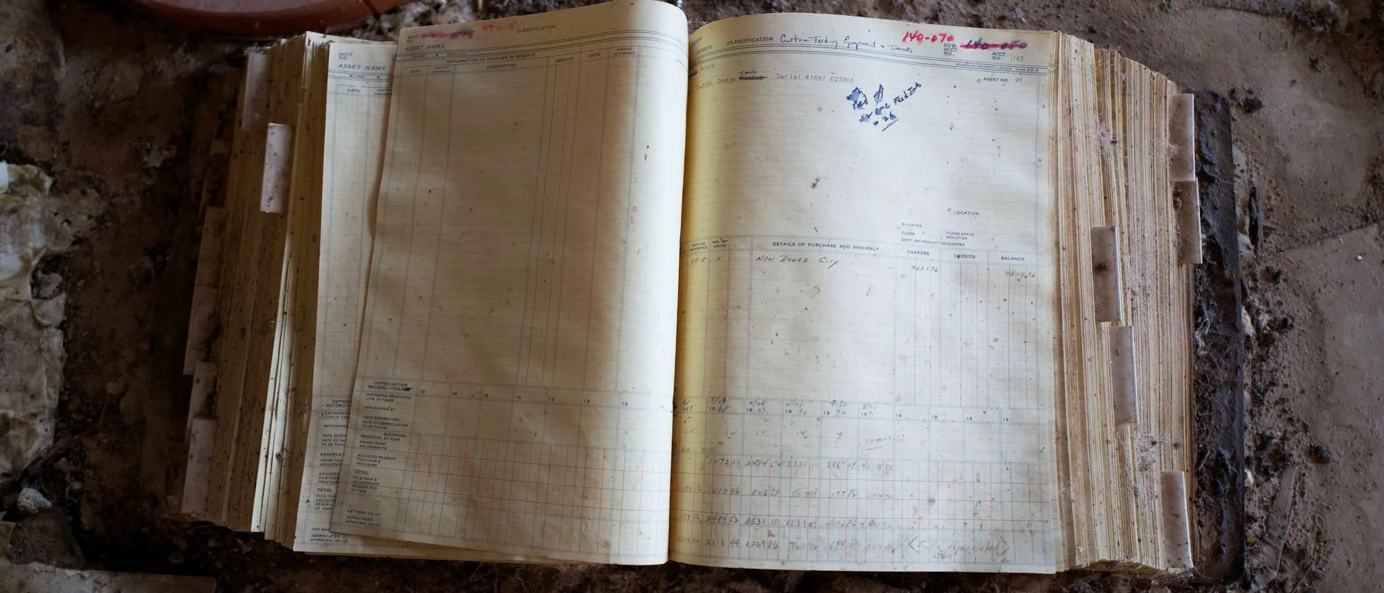 An old open ledger lies on a dusty floor.