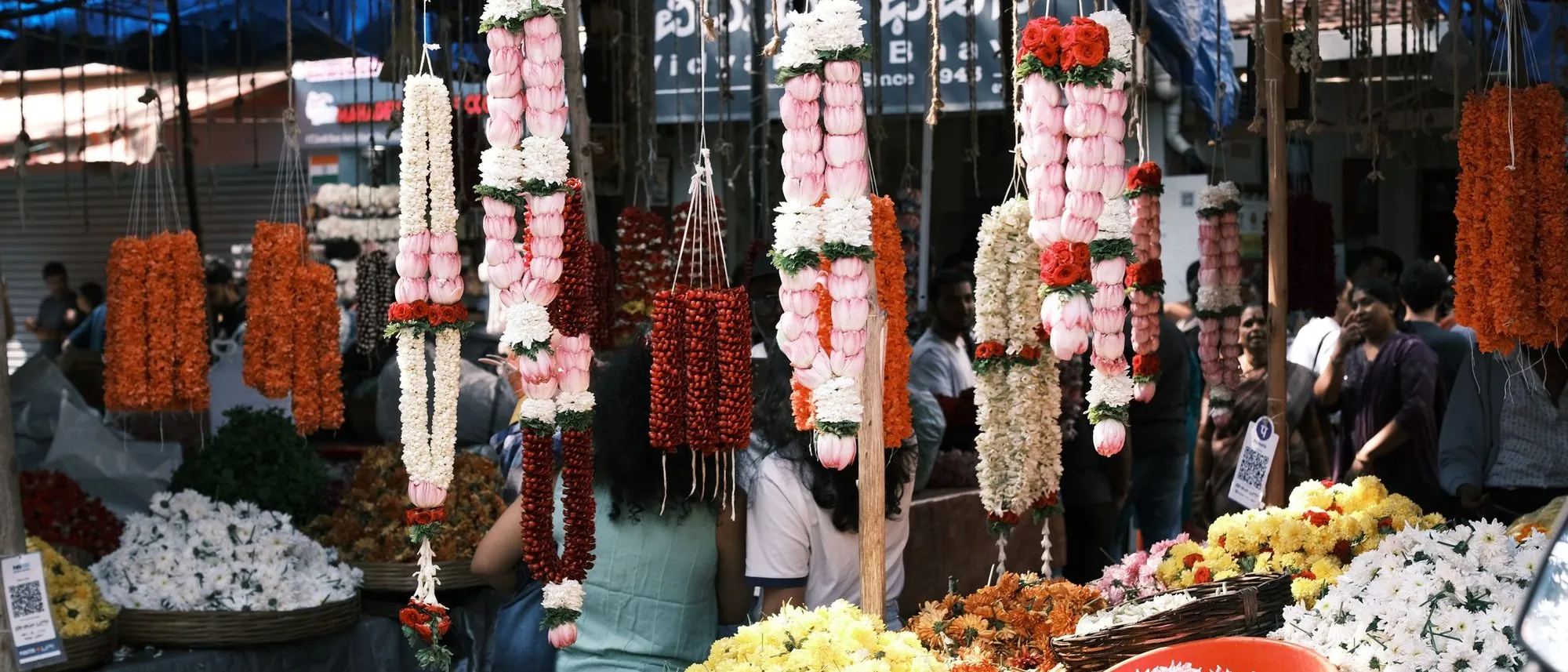 Flower garlands in many colours hang for sale at a market in Bengaluru.