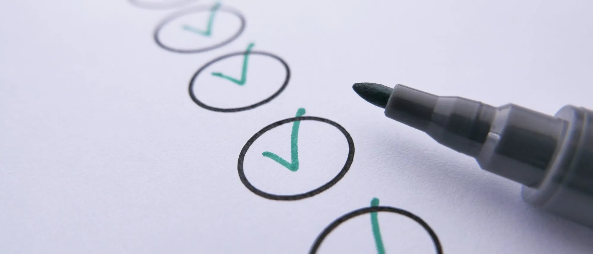 A marker beside a row of hand-ticked circles on white paper