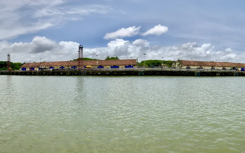 Ships moored along the quays of Cochin Shipyard in Kochi under cranes