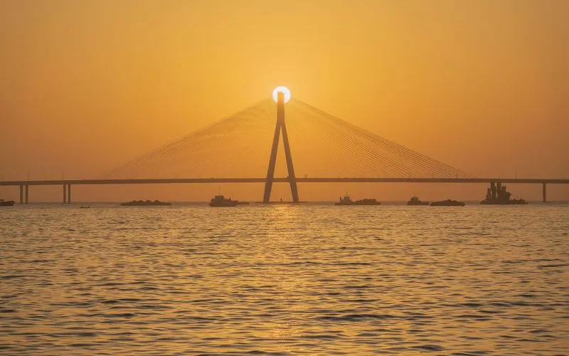 The Bandra-Worli Sea Link stretches across the water at sunset in Mumbai.