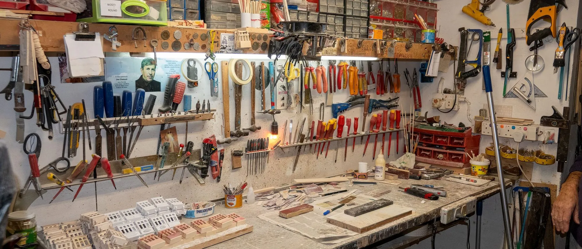 Tools and supplies arranged on racks and benches in a tidy workshop in Malta.