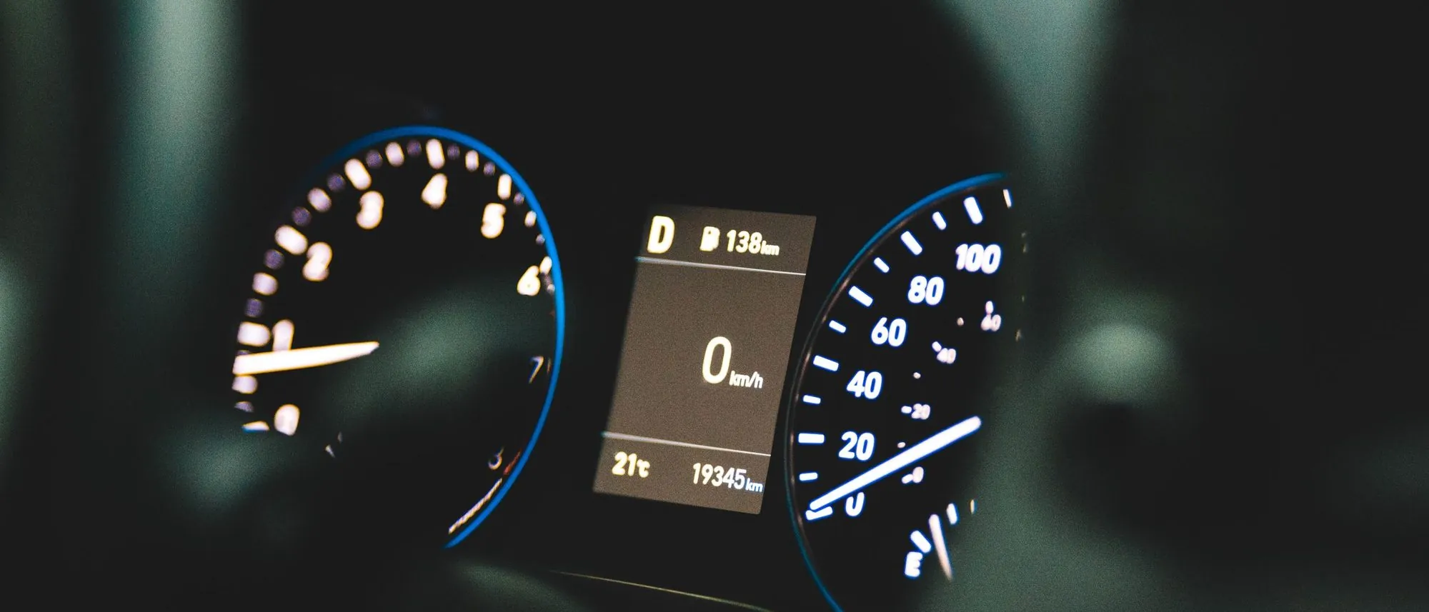 A car dashboard showing the speedometer at zero beside a large odometer reading.