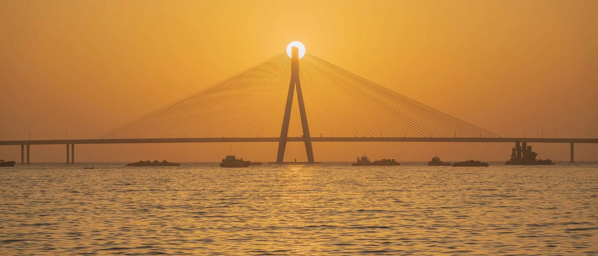 The Bandra-Worli Sea Link stretches across the water at sunset in Mumbai.